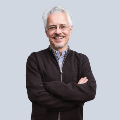 Das männliche Modell trägt eine dunkelbraune Strickjacke mit Reißverschluss.